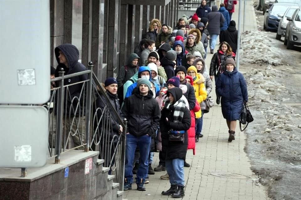 Personas hacen fila para retirar dólares y euros en un cajero de St. Petersburgo, Rusia.