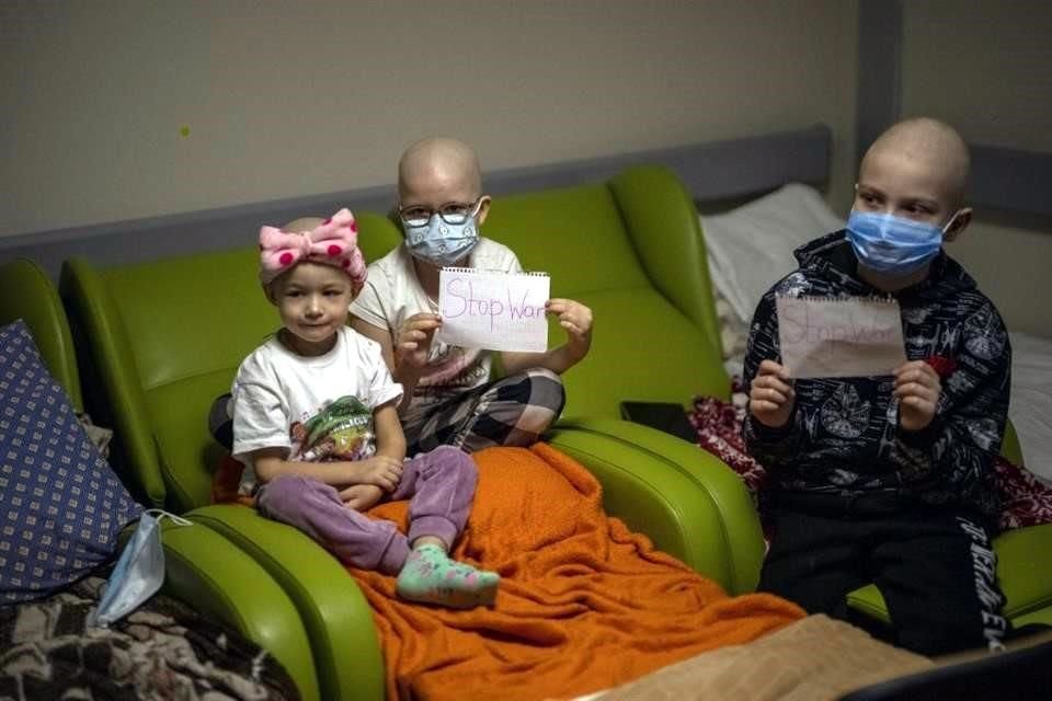 Niños con cáncer muestran mensajes que dicen 'alto a la guerra', mientras se refugian en el hospital Ohmadyt en Kiev.