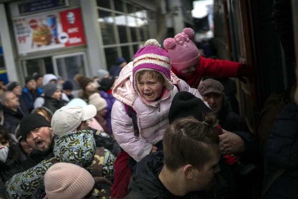 Personas en Kiev tratan de abordar un tren para salir de la ciudad.