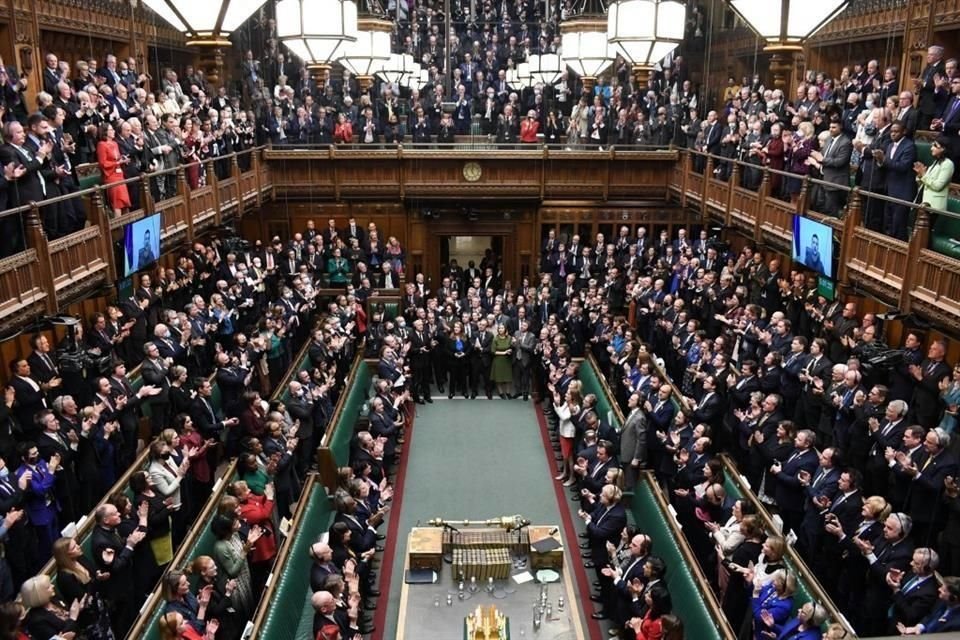 Legisladores británicos en la Cámara de los Comunes aplauden al Presidente ucraniano, Volodymyr Zelensky, quien se dirigió mediante videoconferencia.