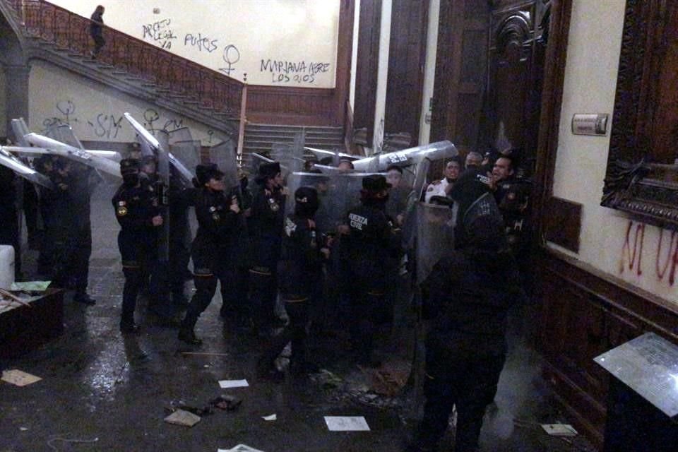 Policías estatales bloquean el paso de manifestantes en el Palacio de Gobierno.