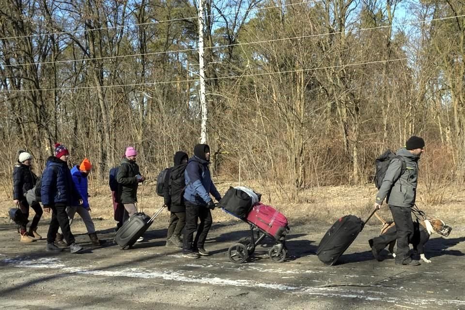 Ucranianos con equipaje caminan para evacuar una región cerca de Kiev.