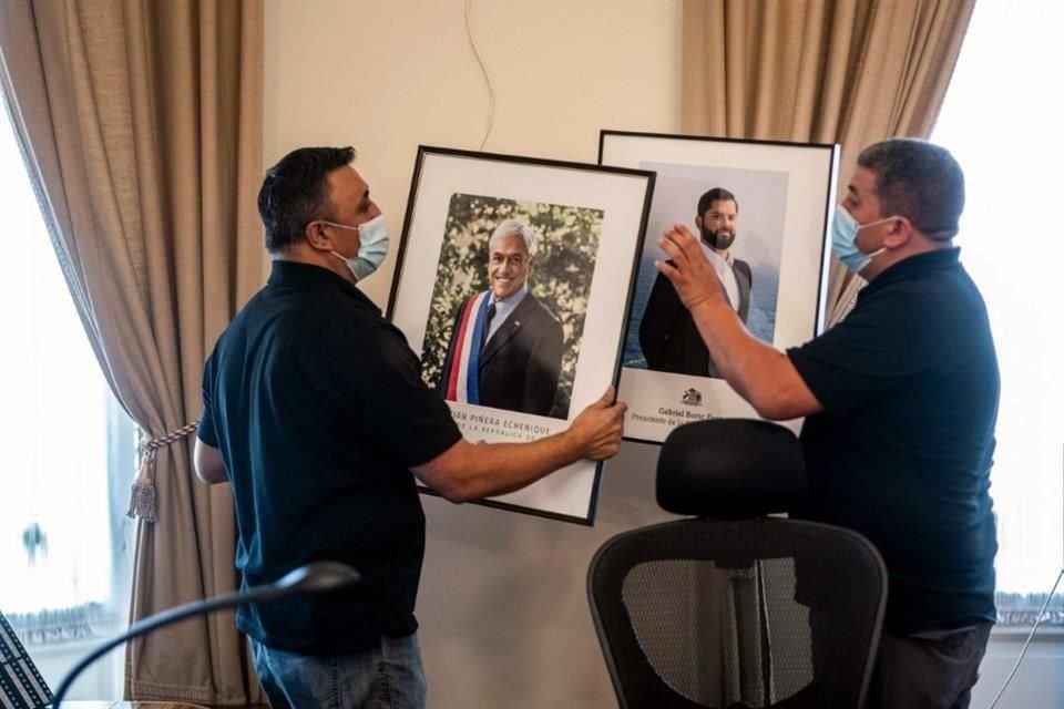 Trabajadores retiran el retrato de Sebastián Piñera en el Palacio de La Moneda y colocan el de Boric.