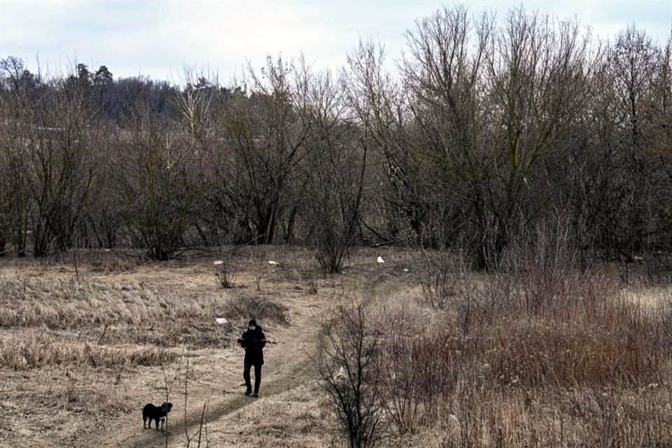 Un soldado ucraniano hace una ronda de vigilancia en un campo de la ciudad de Irpin.