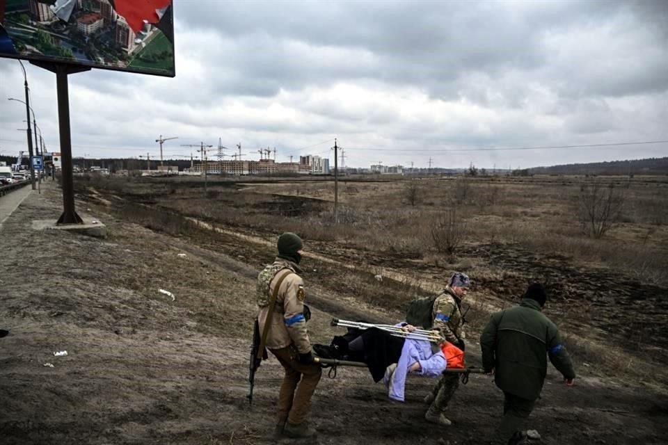 Soldados ucranianos ayudan a una mujer anciana a evacuar la ciudad de Irpin.