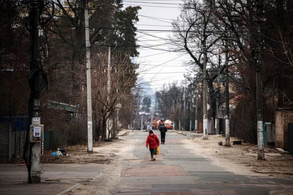 Dos personas caminan por una calle de la ciudad Irpin, a medida que se ha quedado vacía por la invasión rusa.
