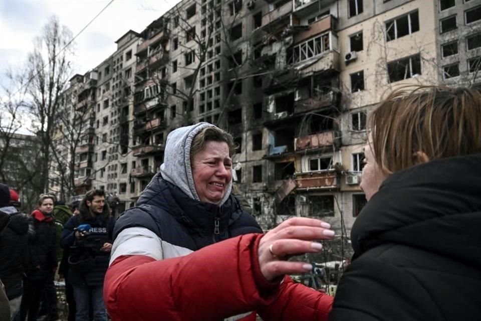 Una mujer llora al ver el daño que causaron misiles rusos a un edificio de departamentos en Kiev.