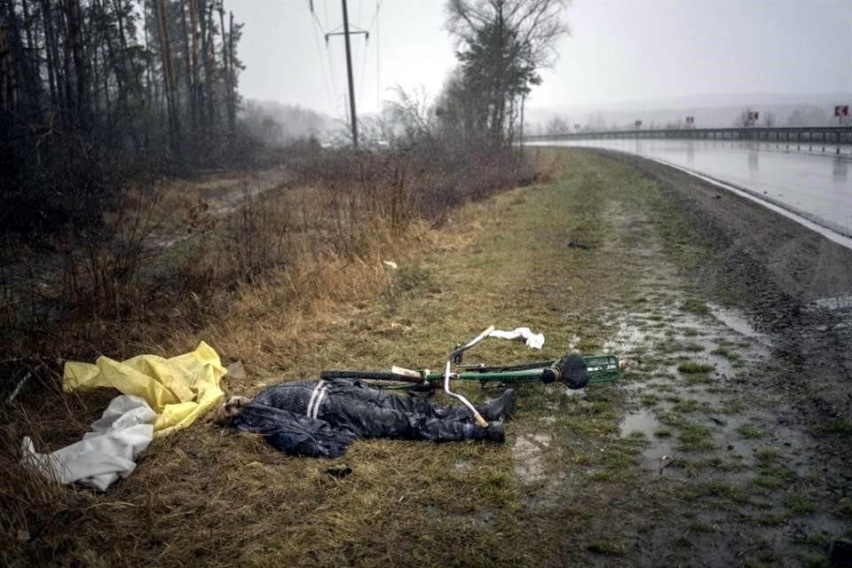 un hombre yace muerto junto a una bicicleta en Bucha, a las afueras de Kiev.