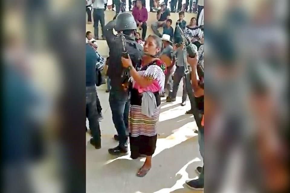 Una mujer empuña el arma incautada a policías.