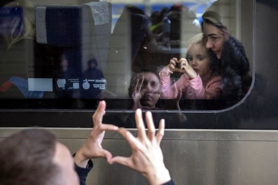 Un ucraniano dice adiós a su hija y a su esposa en un tren que va a Polonia.