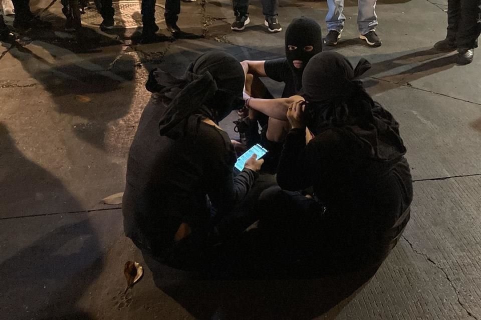 Tres mujeres encapuchadas fueron llevadas hacia el exterior de la sede de la CNDH acompañadas por autoridades.