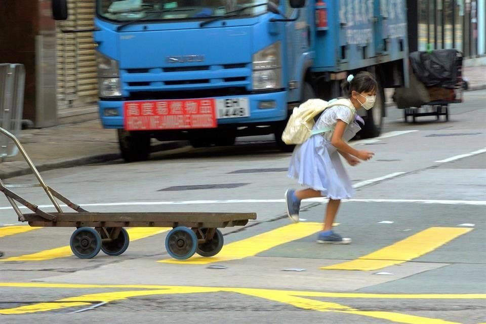 Pequeña jugando en una calle de la ciudad de Hong Kong.