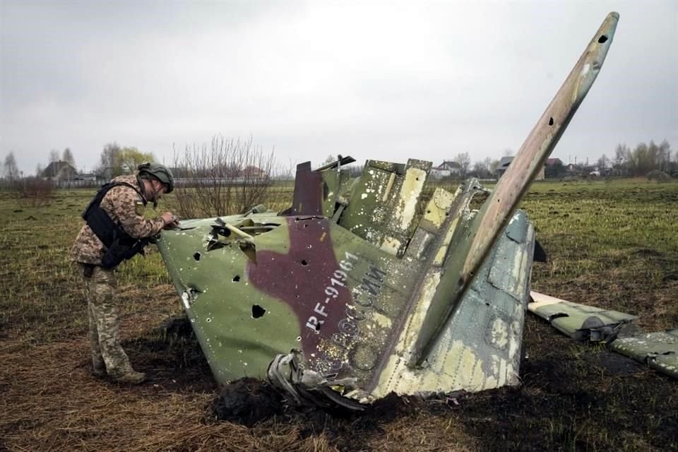 Un soldado ucraniano examina restos de un jet Su-25 ruso cerca de Kolonshchyna, Ucrania.