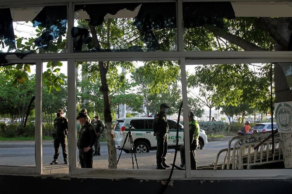 Varios policías vigilan una estación de policía afectada durante una jornada de protestas en la noche de este martes, en Cartagena, Colombia.