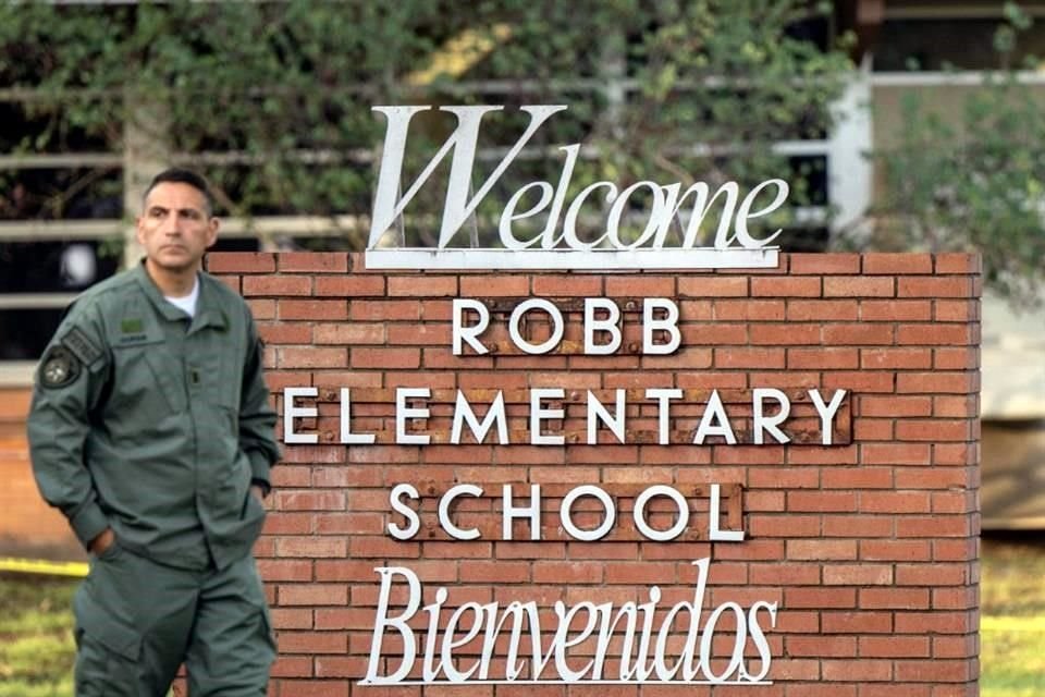 Un oficial de la Policía de Texas camina junto a un letreto de la Escuela Primaria Robb, donde ayer mataron a 21 personas.