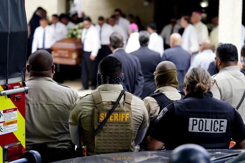 Policías de la comunidad miran cómo llegan los ataúdes de los García.