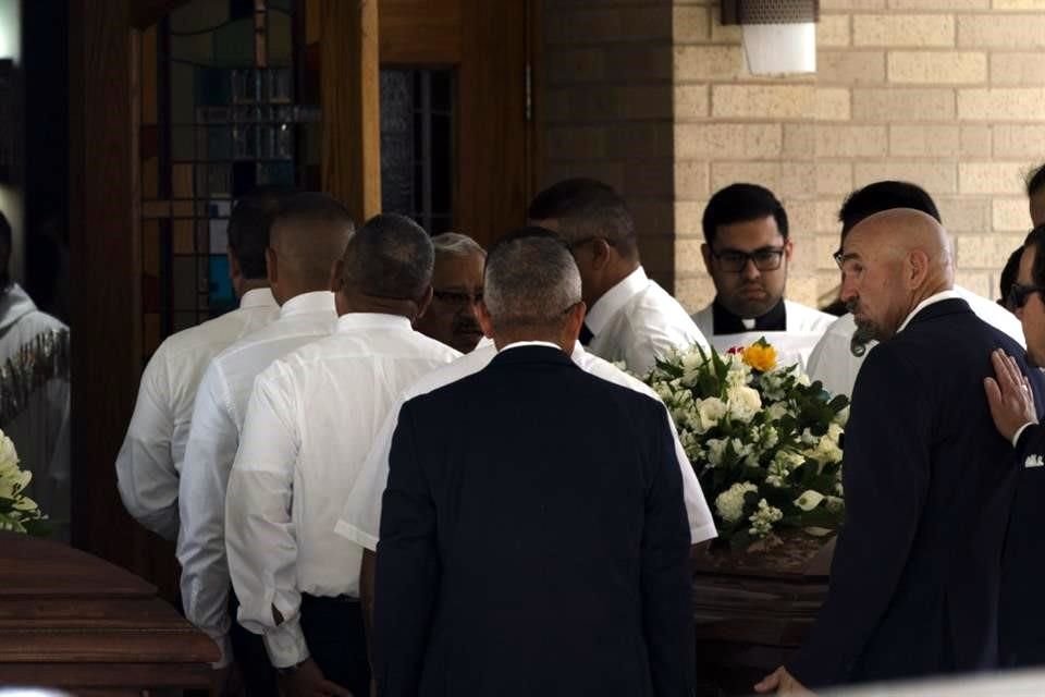 Los portadores del féretro entran a la Iglesia Católica del Sagrado Corazón.