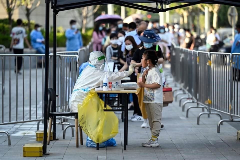 Un trabajador de salud toma una muestra a un menor para una prueba de Covid-19, en Beijing, China.