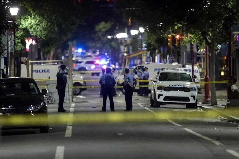 Oficiales y detectives de la policía de Filadelfia revisan evidencia en la escena.