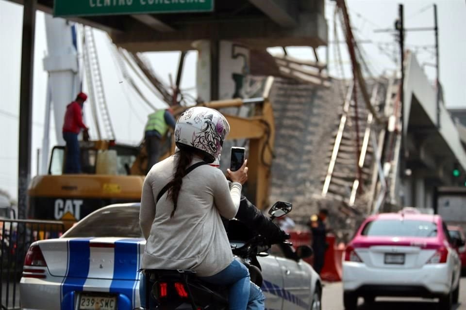 En el lugar del colapso, autobuses, carros y motos bajan su velocidad para apreciar lo mayor posible el siniestro en la Línea Dorada.