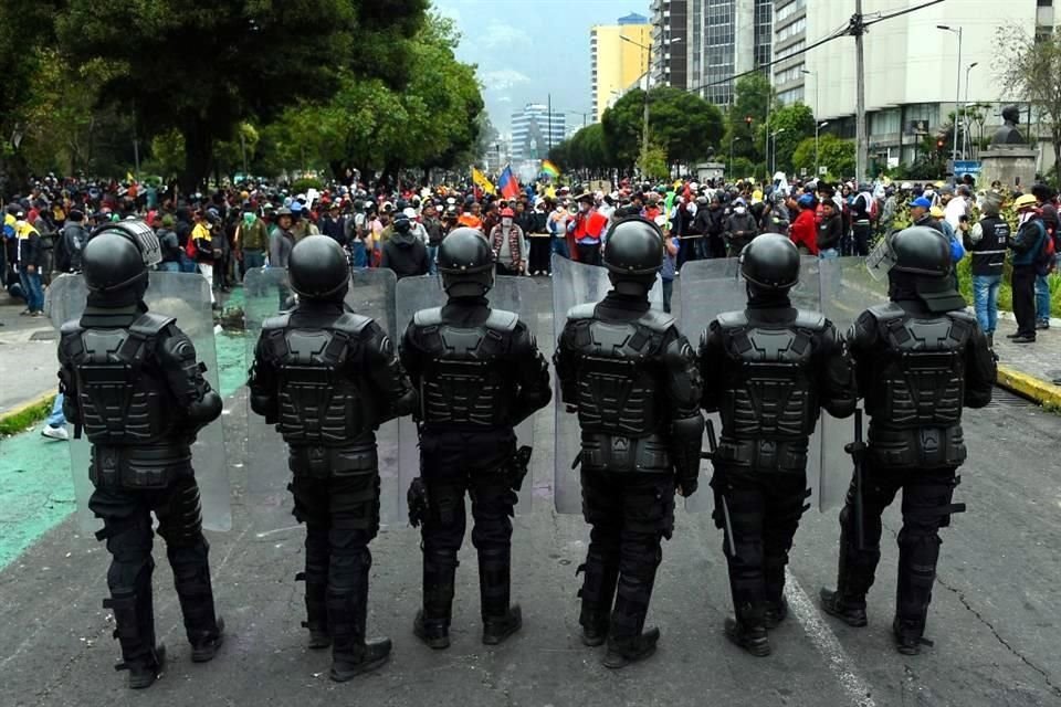 Policías antimotines de Quito resguardan el parque de El Arbolito, en la capital de Ecuador.