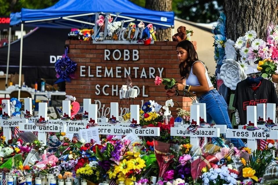 Una niña deposita flores en un memorial instalado afuera de la Escuela Primaria Robb de Uvalde, Texas, tras el tiroteo masivo en el que murieron 19 niños y dos maestras.