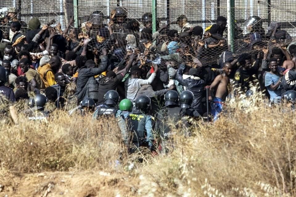 Migrantes llegan a suelo español después de cruzar las vallas que separan el enclave español de Melilla de Marruecos en Melilla, España.