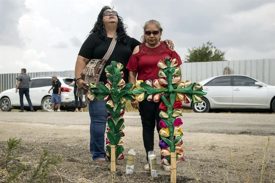 Algunas personas llevaron arreglos y rezaron en el sitio donde un tráiler con migrantes fue encontrado en San Antonio, Texas.