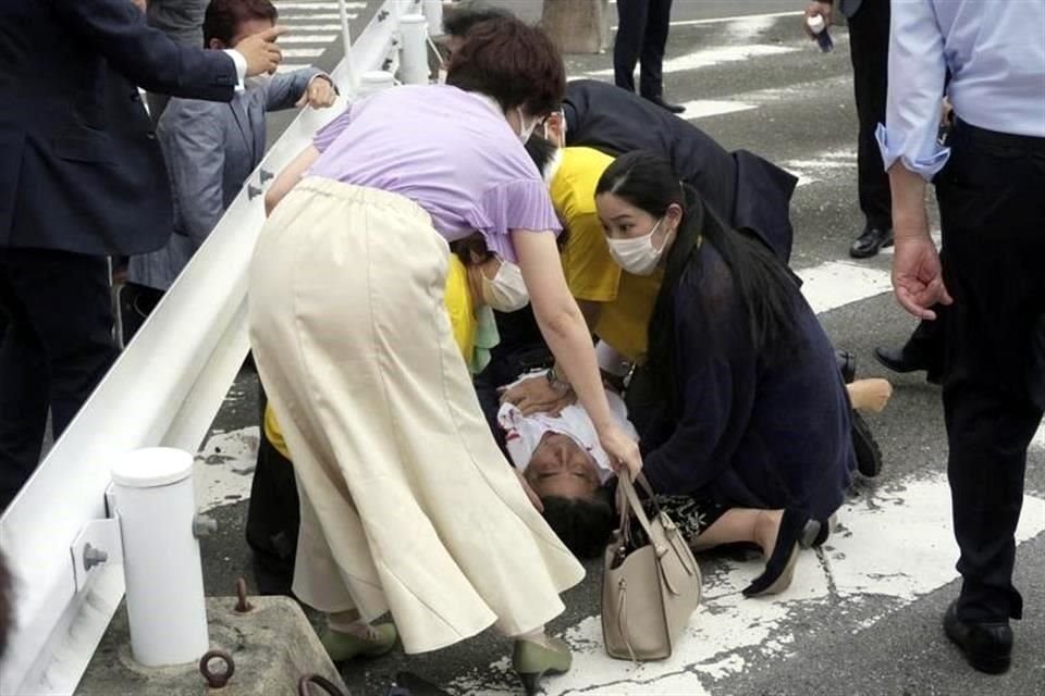 El ex Primer Ministro de Japón Shinzo Abe, centro, cae al suelo en Nara, oeste de Japón, tras recibir un disparo.