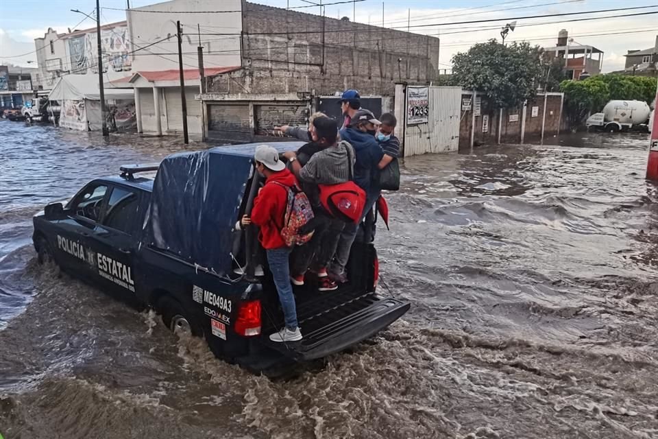 Decenas de personas tuvieron que abordar patrullas de la Policía Municipal y transportes particulares para poder cruzar las calles anegadas.