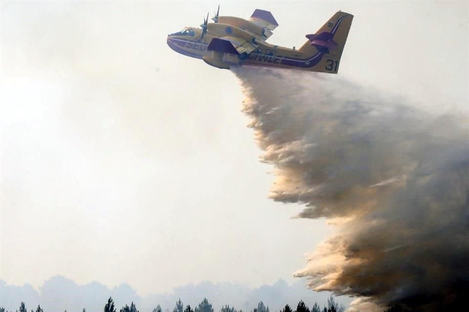 Un avión arroja agua sobre un incendio forestal en Landiras, en el suroeste de Francia.