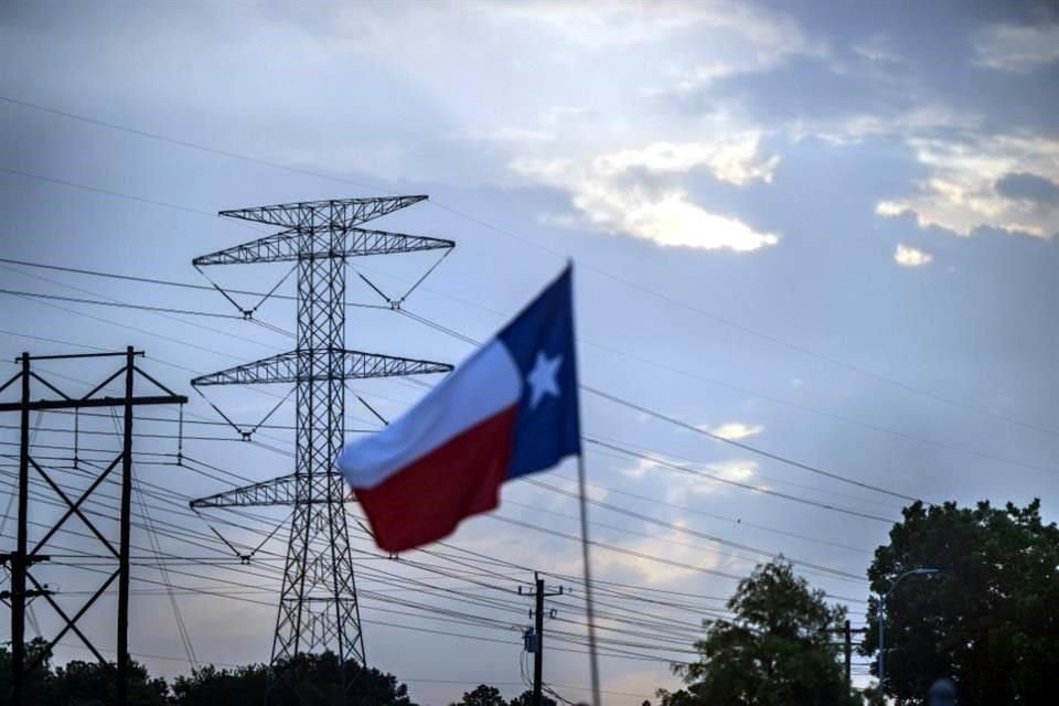 La bandera de Texas es vista en Houston, con una torre eléctrica de fondo, días después de que las autoridades pidieron ahorrar energía por la alta demanda derivada de la ola de calor.