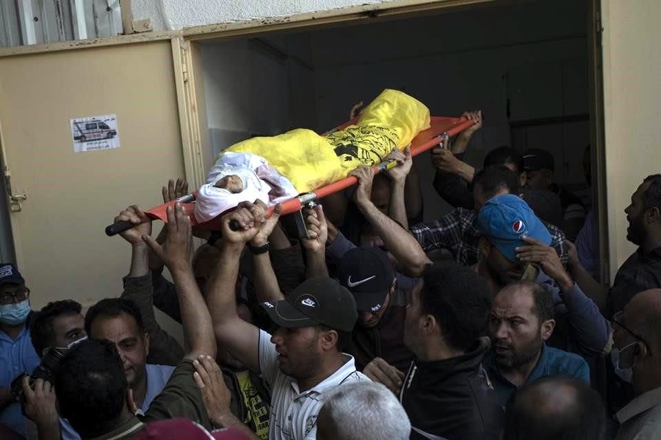 Palestinos en la Franja de Gaza cargan el cuerpo de un niño de 11 años que fue asesinado por los bombardeos de Israel.