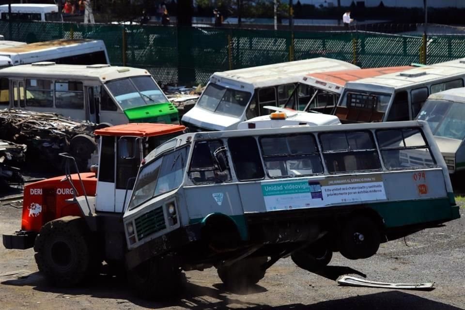 En la Alcaldía Iztapalapa, un puente reúne a personas que contemplan el proceso de desecho de microbuses, incluso hasta se toman fotos