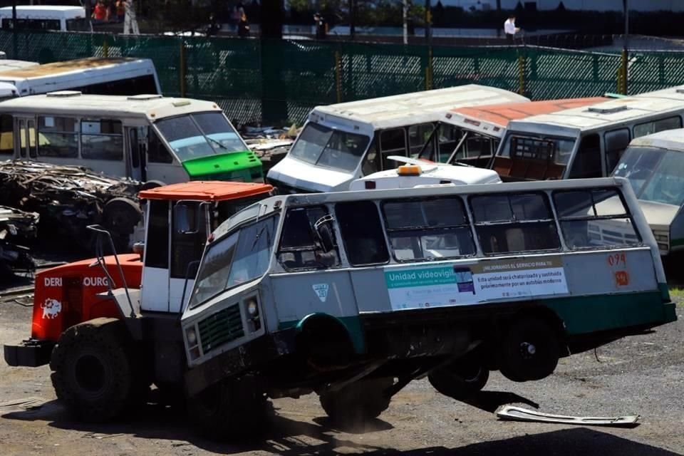 En la Alcaldía Iztapalapa, un puente reúne a personas que contemplan el proceso de desecho de microbuses, incluso hasta se toman fotos