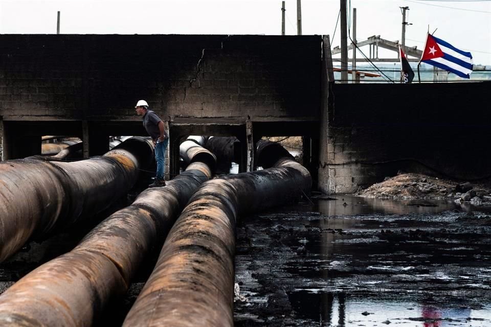 Un empleado de la compañía estatal de petróleo Cupet inspecciona el daño en el depósito de combustible consumido por las llamas durante cinco días después de que un rayo pegó en uno de los tanques.