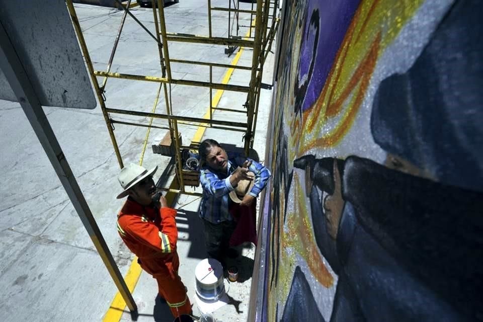 Jesús Rodríguez, cofundador de la escuela,  instruye a Luis Manuel Velez mientras detallan el mural en el auditorio de San Salvador.