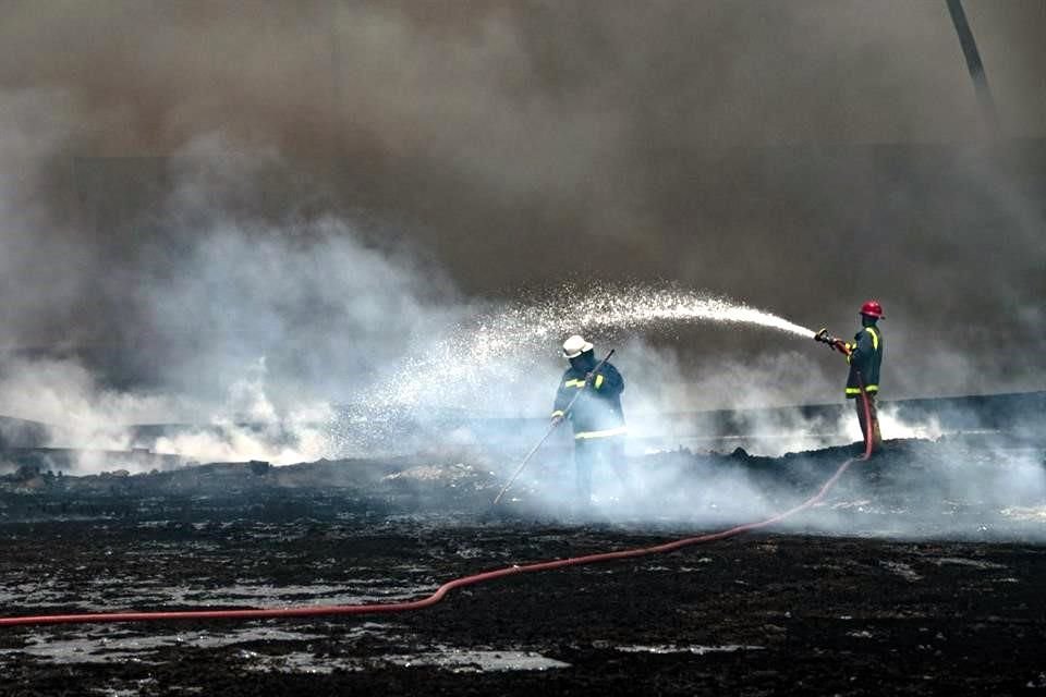 Bomberos en la base de petróleo de Matanzas, Cuba, trabajan apagando los remanentes del incendio.