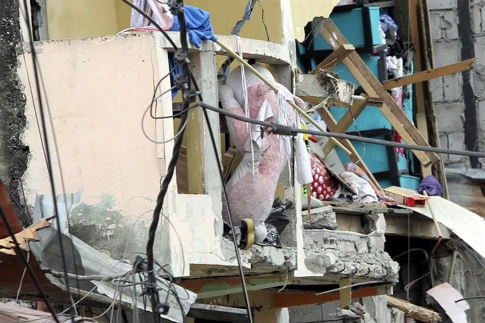 Pertenencias se ven por los huecos que dejó la explosión en el barrio de Cristo de El Consuelo.