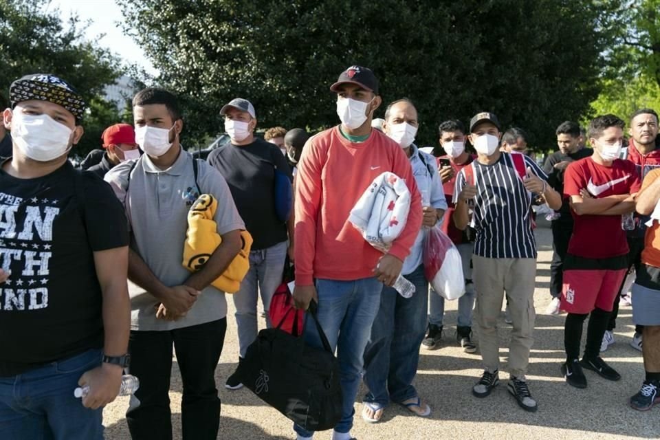 Migrantes sostienen mantas de la Cruz Roja después de llegar a Union Station, cerca del Capitolio de EU, desde Texas, el pasado abril.