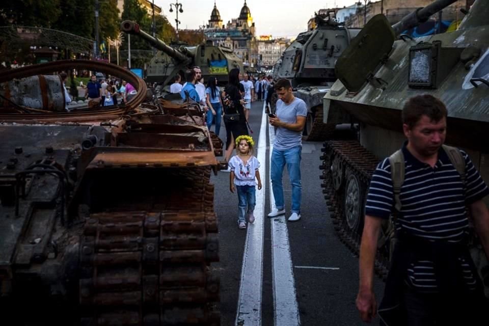 Personas, incluyendo niños, miran los tanques rusos destruidos en el centro de Kiev.