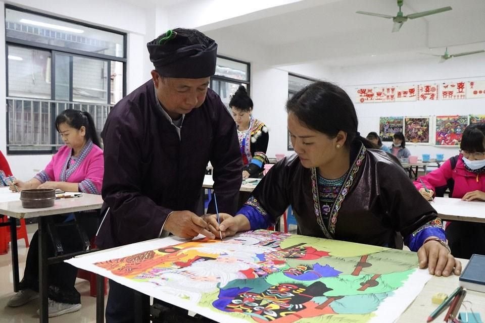 En el Centro Cultural del Condado Autónomo de la Etnia Miao de Rongshui, ciudad de Liuzhou, en Guangxi, Miao Jialin, experto en pintura de los campesinos enseña a los estudiantes a pintar.