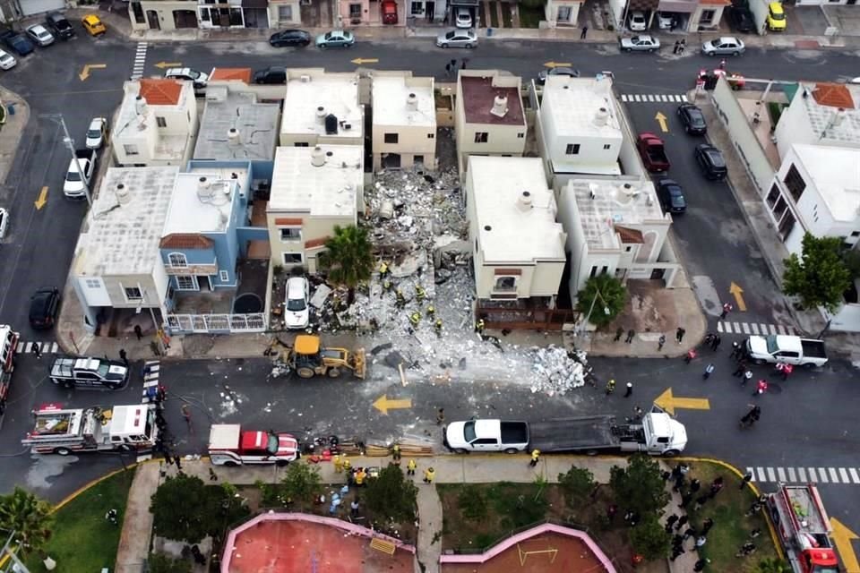 Con ayuda de una retroexcavadora, personal de Bomberos y Protección Civil buscan en los escombros.