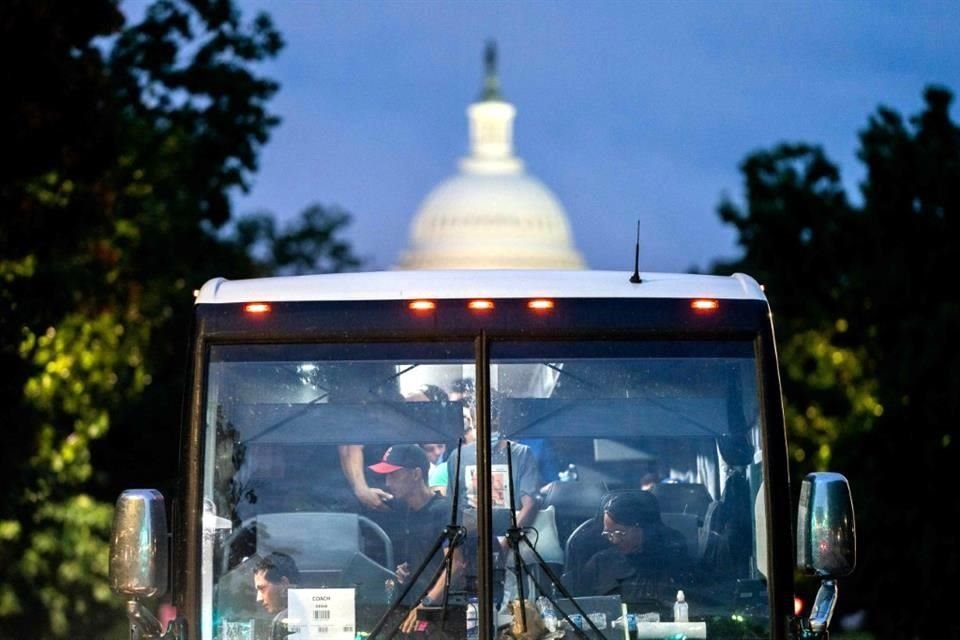 Migrantes llegan al Capitolio en un camión que abordaron en Texas.