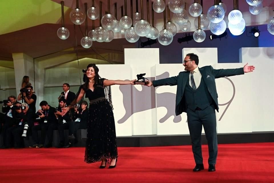 La actriz franco-iraní Mina Kavani y el actor iraní Reza Heydari posan con el Premio Especial del Jurado que recibieron, en nombre del director iraní encarcelado Jafar Panahi.