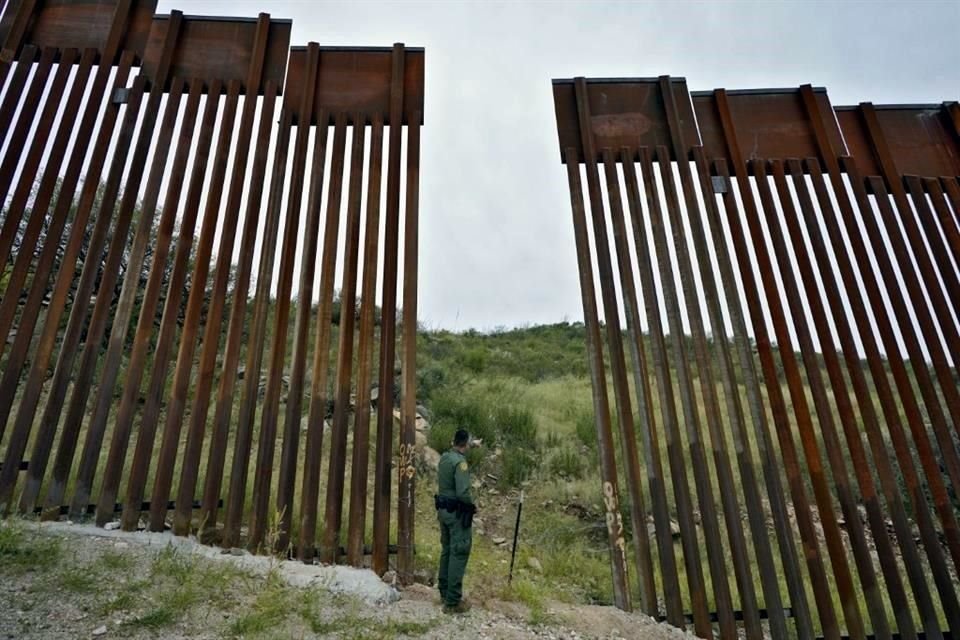 Un agente de la Patrulla Fronteriza mira a través de una brecha del muro en  Sasabe, Arizona.