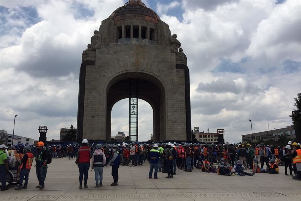 Los trabajadores de la Torre de 50 pisos Vigram Reforma, en construcción, esperan también en la explanada del monumento la Revolución.