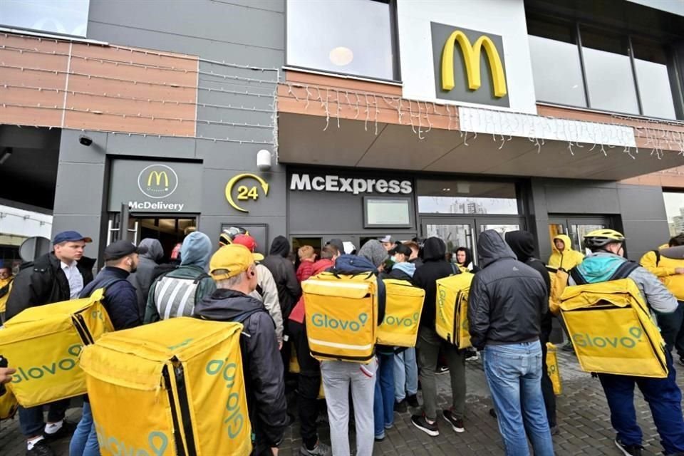 Los empleados de entrega se reúnen en un restaurante de McDonald's para recoger los pedidos en Kyiv, luego de que la cadena reabrió en la capital ucraniana tras más de seis meses de la invasión rusa.