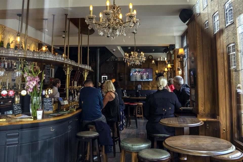 Personas en un pub de Londres miran un programa sobre la Reina Isabel II recién fallecida.