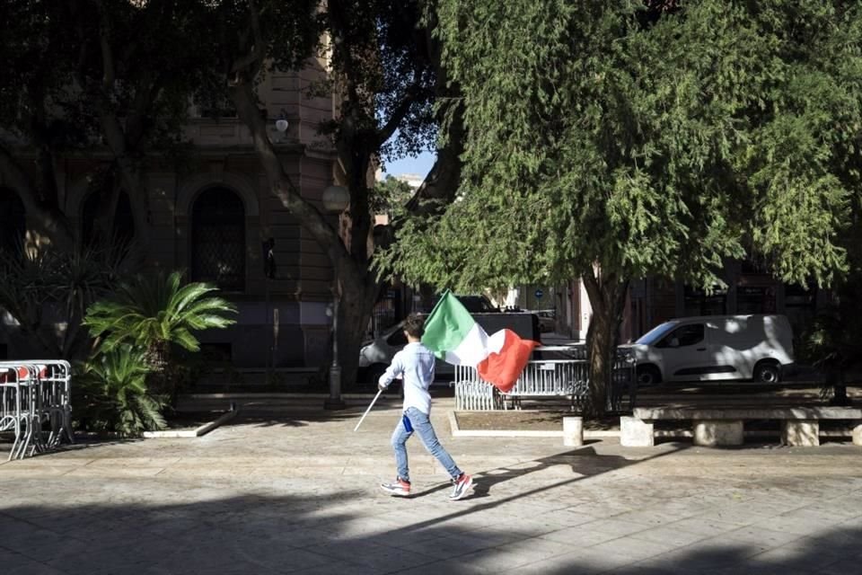 Un simpatizante de Giorgia Meloni y del partido de extrema derecha Hermanos de Italia carga la bandera de Italia en un evento de campaña en Caligari.